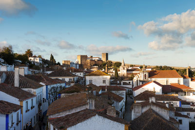 High angle view of houses in town against sky