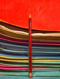 Close-up of multi colored pencils on table against wall