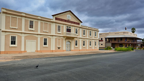 Building by road against sky in city