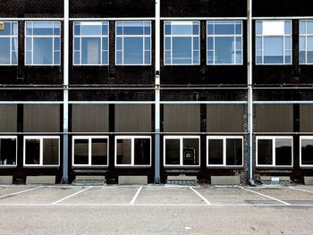 Windows of an industrial building and parking lot.