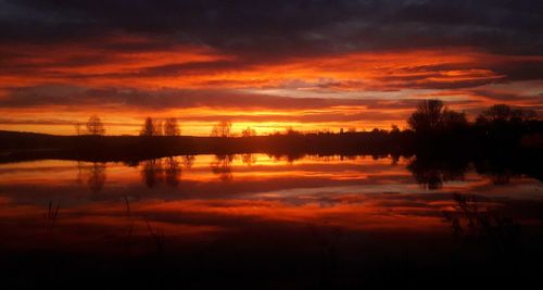 Scenic view of lake against romantic sky at sunset