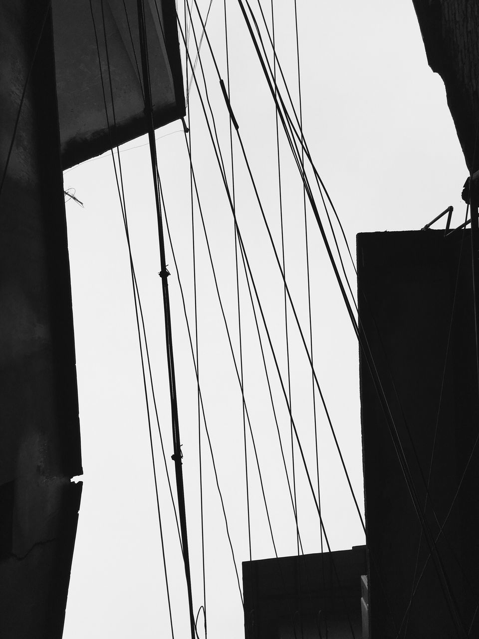 low angle view, built structure, architecture, building exterior, clear sky, power line, silhouette, cable, connection, city, electricity pylon, tall - high, sky, building, outdoors, electricity, day, no people, tower, power supply