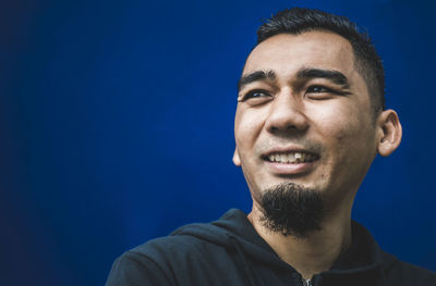 Portrait of young man against blue background