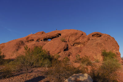 Low angle view of rock formation against clear blue sky