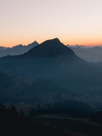 Scenic view of silhouette mountains against sky during sunset