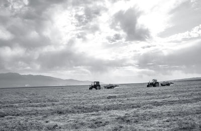 People on agricultural field against sky