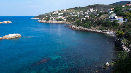 High angle view of houses by sea against sky