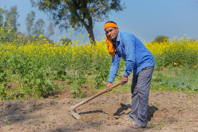 Full length portrait of man working on field