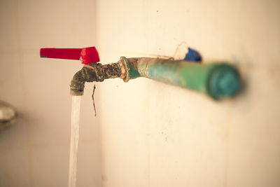 Close-up of faucet against wall