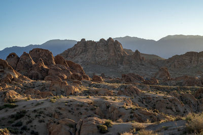 Scenic view of rocky desert with mountains against clear sky