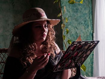 Woman reading book while sitting at home