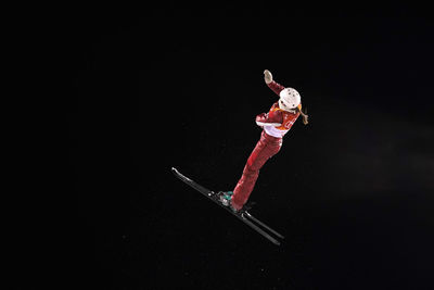 Man in mid-air over black background