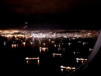 Illuminated cityscape against sky at night