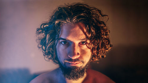 Close-up portrait of bearded man against wall