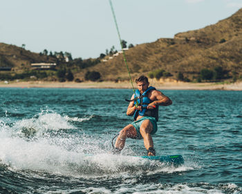 Full length of man wakeboarding in sea