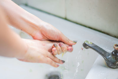 Cropped image of woman washing hands in sink