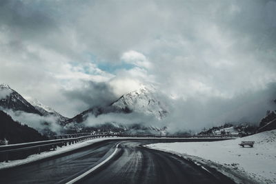 Road passing through mountains in winter