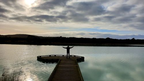 Silhouette pier on lake against sky during sunset