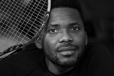 Close-up portrait of man holding tennis racket