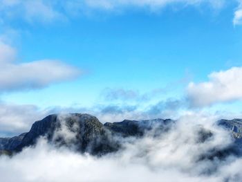 Scenic view of clouds over mountain against blue sky