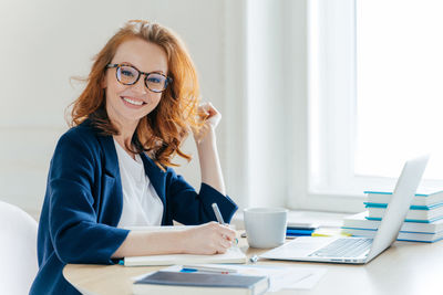 Portrait of businesswoman working at desk in office