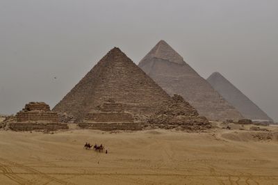 View of people riding horse in desert