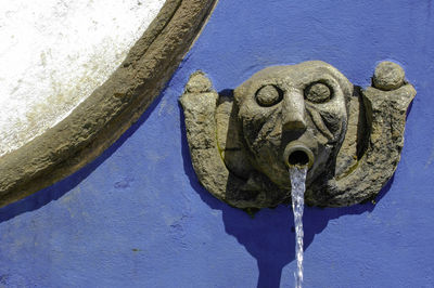 Close-up of old sculpture against wall