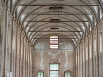 Empty white interiors without people in an old hospital building in parma, italy.