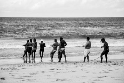 People at beach against sky