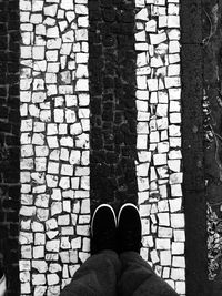 Low section of person standing on tiled floor