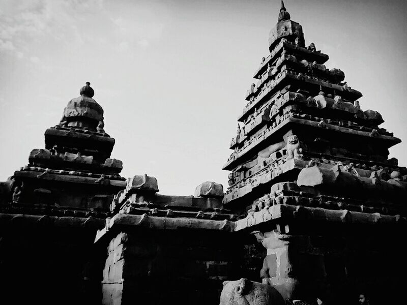 low angle view, architecture, built structure, building exterior, human representation, religion, sculpture, clear sky, statue, art and craft, sky, place of worship, famous place, spirituality, history, art, travel destinations, creativity, tourism