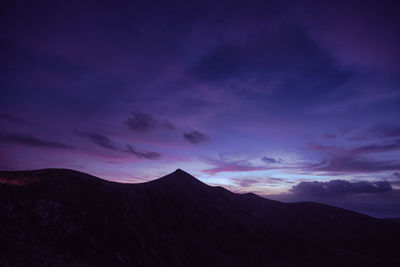 Scenic view of silhouette mountains against dramatic sky