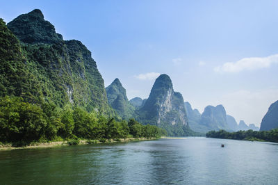 Scenic view of river and mountains against sky