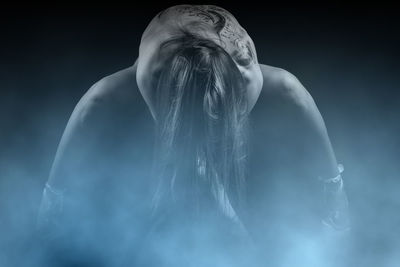 Rear view of shirtless woman against gray background