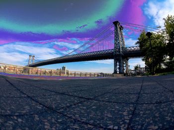 Suspension bridge against cloudy sky