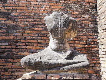 Old statue against brick wall