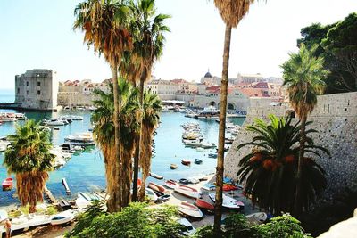 Boats in sea with buildings in background