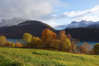 Scenic view of fjord and mountains against cloudy sky