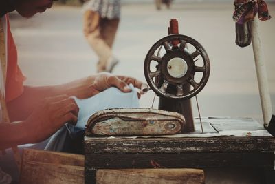 Cropped hand of person sewing cloth on machine