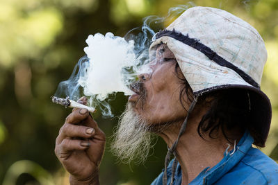 Close-up portrait of man smoking cigarette