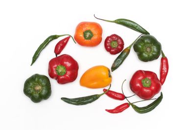 High angle view of red bell peppers against white background