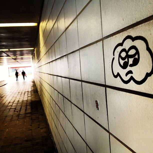 indoors, men, lifestyles, walking, architecture, built structure, full length, person, leisure activity, wall - building feature, ceiling, corridor, steps, subway, tiled floor, flooring, the way forward, illuminated