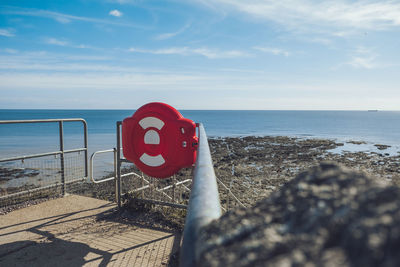 Road sign on beach against sky