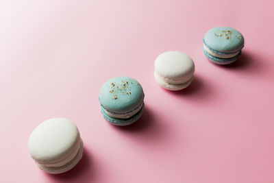 White and blue macaroons on the table, macaroons on pink background. high quality photo