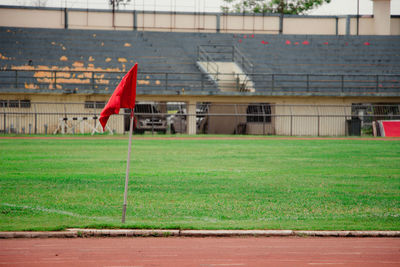 Red umbrella on field against buildings