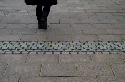 Low section of woman standing on tiled floor