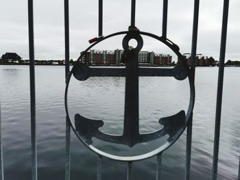 Metal railing on river against sky