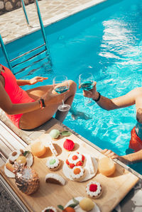 Boyfriend and girlfriend drinking wine by the pool