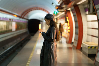 Rear view of woman standing on railroad station platform