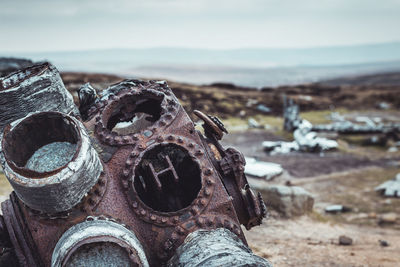 Close-up of rusty machine part on field